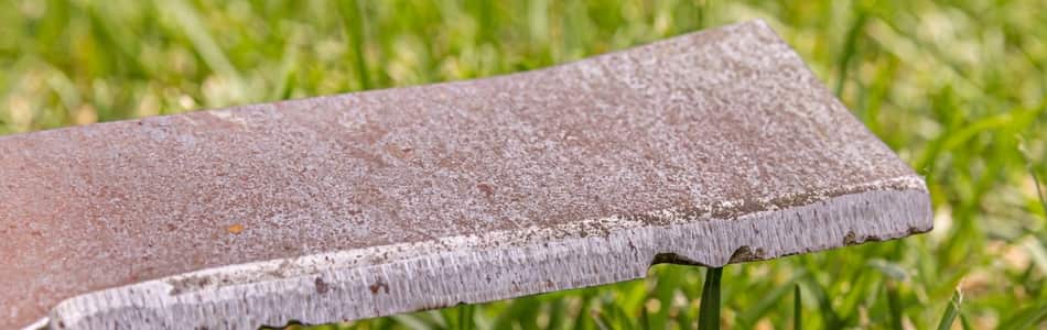 Worn mower blade with chips in the blade edge