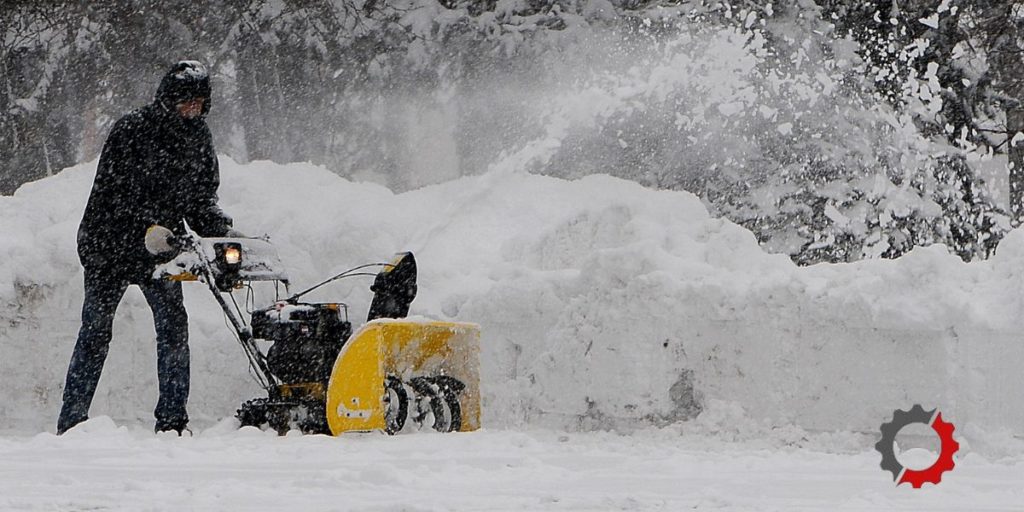 Man pushing a yellow snowblower 
